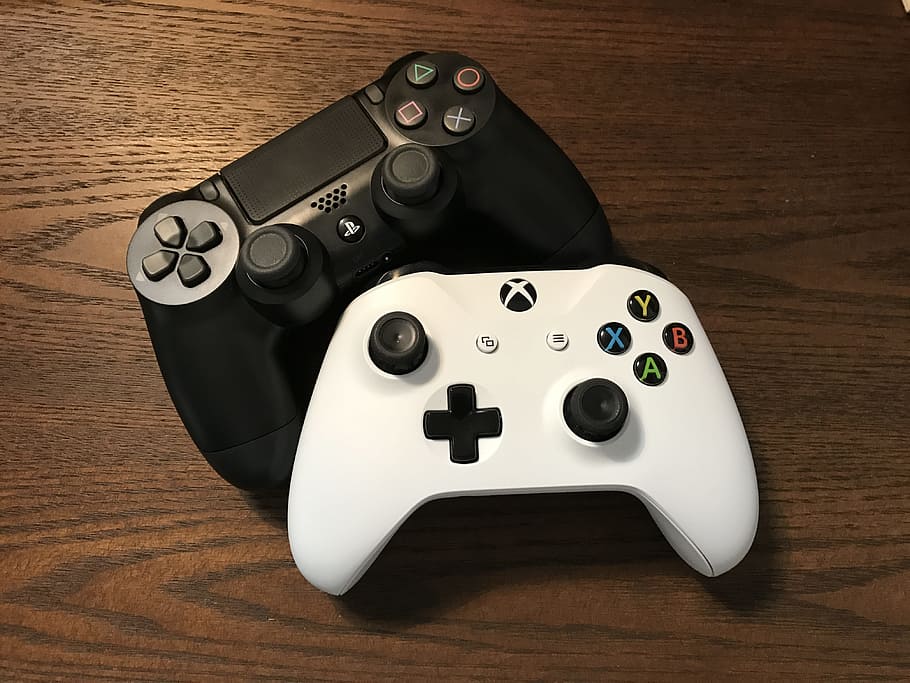 White Xbox and Sony PS4 Controllers on Brown Surface, Video Game.